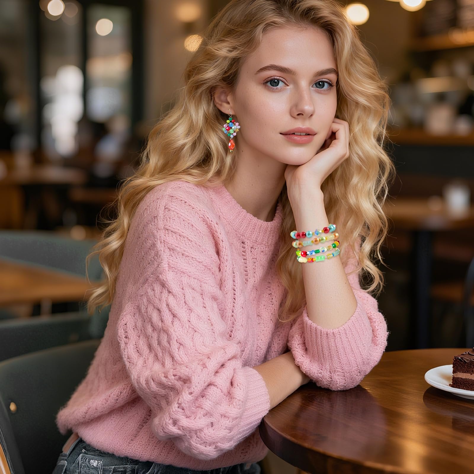 Woman wearing colorful beaded earrings and bracelets in a cafe setting