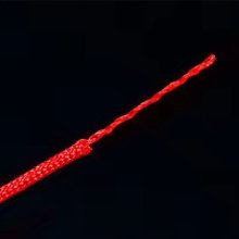 Close-up of the end of a red nylon cord, showing its braided texture and frayed tip against a black background.