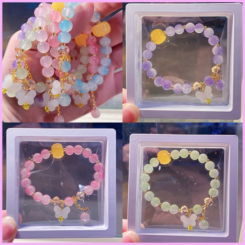 Assortment of colorful beaded bracelets with butterfly charms, some displayed in clear boxes.