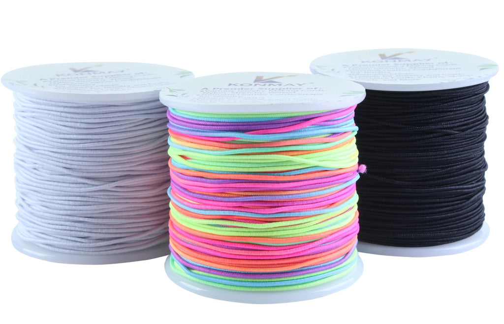 Three spools of elastic beading cord: one white, one multi-colored, and one black, shown from the front.