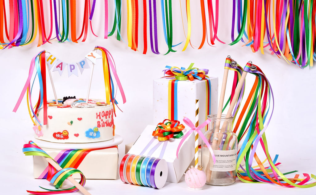 Birthday cake with 'Happy Birthday' text and colorful ribbons, gift boxes, and ribbon rolls on a white background.