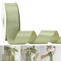 Roll of dusty sage satin ribbon with a wavy tail, shown with examples of use on a cake, gift box, and bouquet.