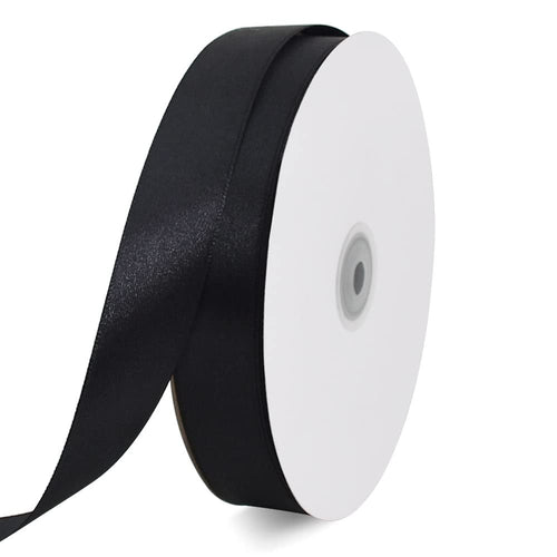 Roll of black satin ribbon on a white spool, angled view, isolated on white background.