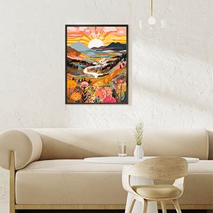Framed colorful landscape painting with mountains, river, and flowers hanging on a textured wall above a sofa.