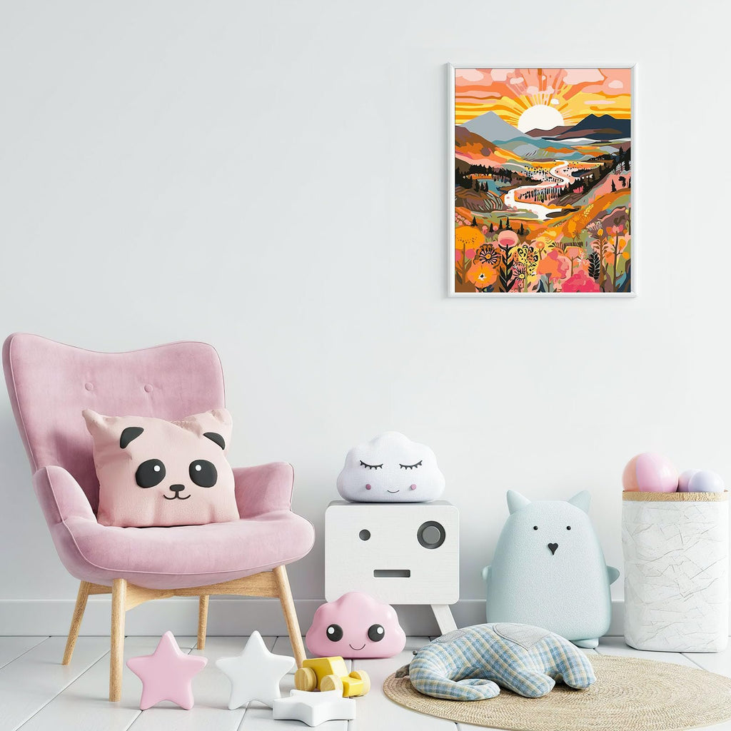 Framed colorful landscape painting of a river valley at sunset hanging on a white wall above a pink armchair.