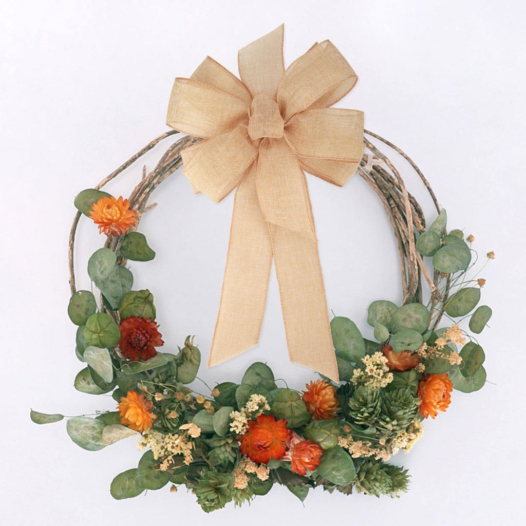 Rustic wreath with burlap bow and dried flowers, eucalyptus leaves, and green accents on a white background.