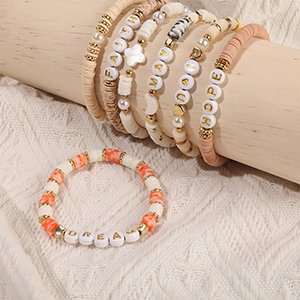 Assortment of handmade beaded bracelets with letter beads spelling out words like HOPE and DREAM, displayed on a textured surface.