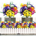 Two bouquets of artificial pansy flowers and a planter box filled with artificial pansy flowers behind a white picket fence.