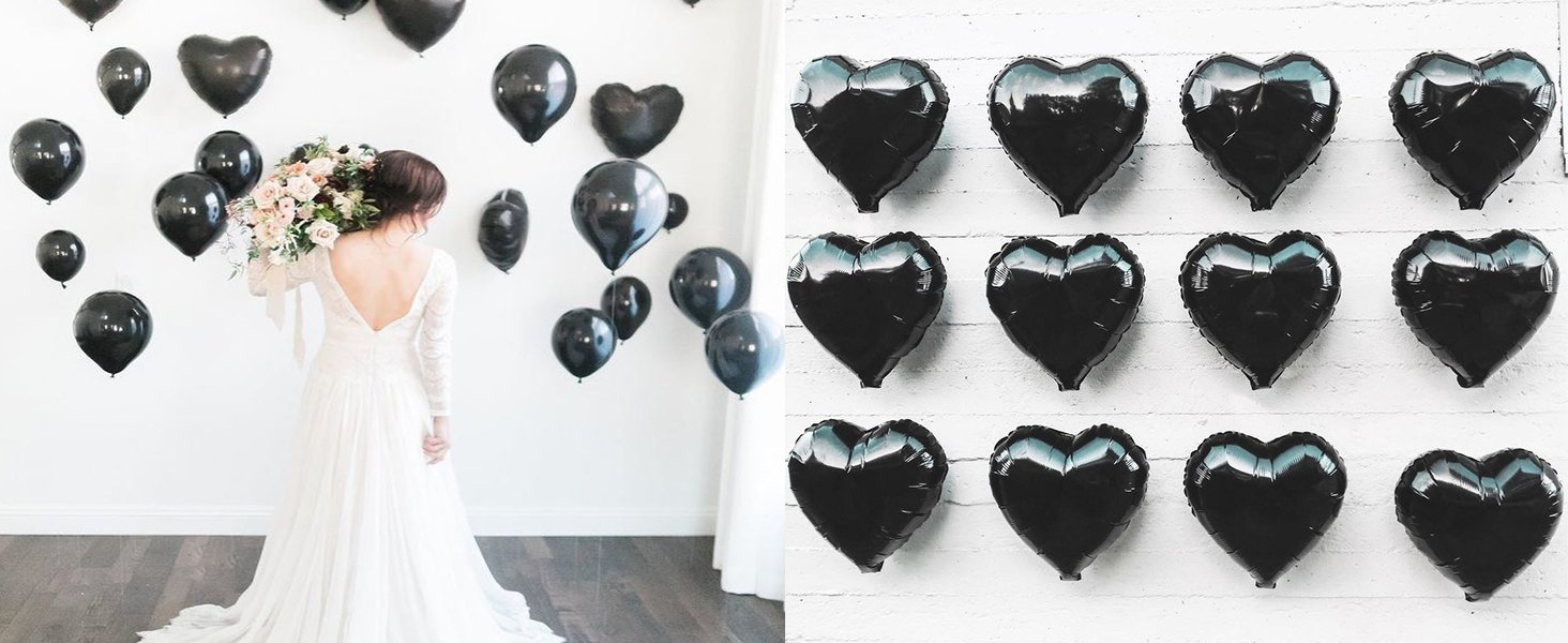 Bride in white dress holding bouquet with black heart and round balloons on white wall