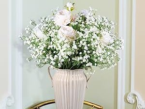 Bouquet of artificial baby's breath and roses in a cream vase, arranged for home decor.