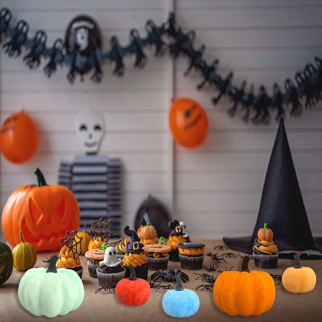 Halloween scene with decorative pumpkins, cupcakes, and spooky decorations on a table