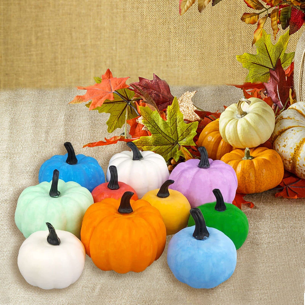Assortment of colorful mini pumpkins and autumn leaves arranged on a burlap surface.