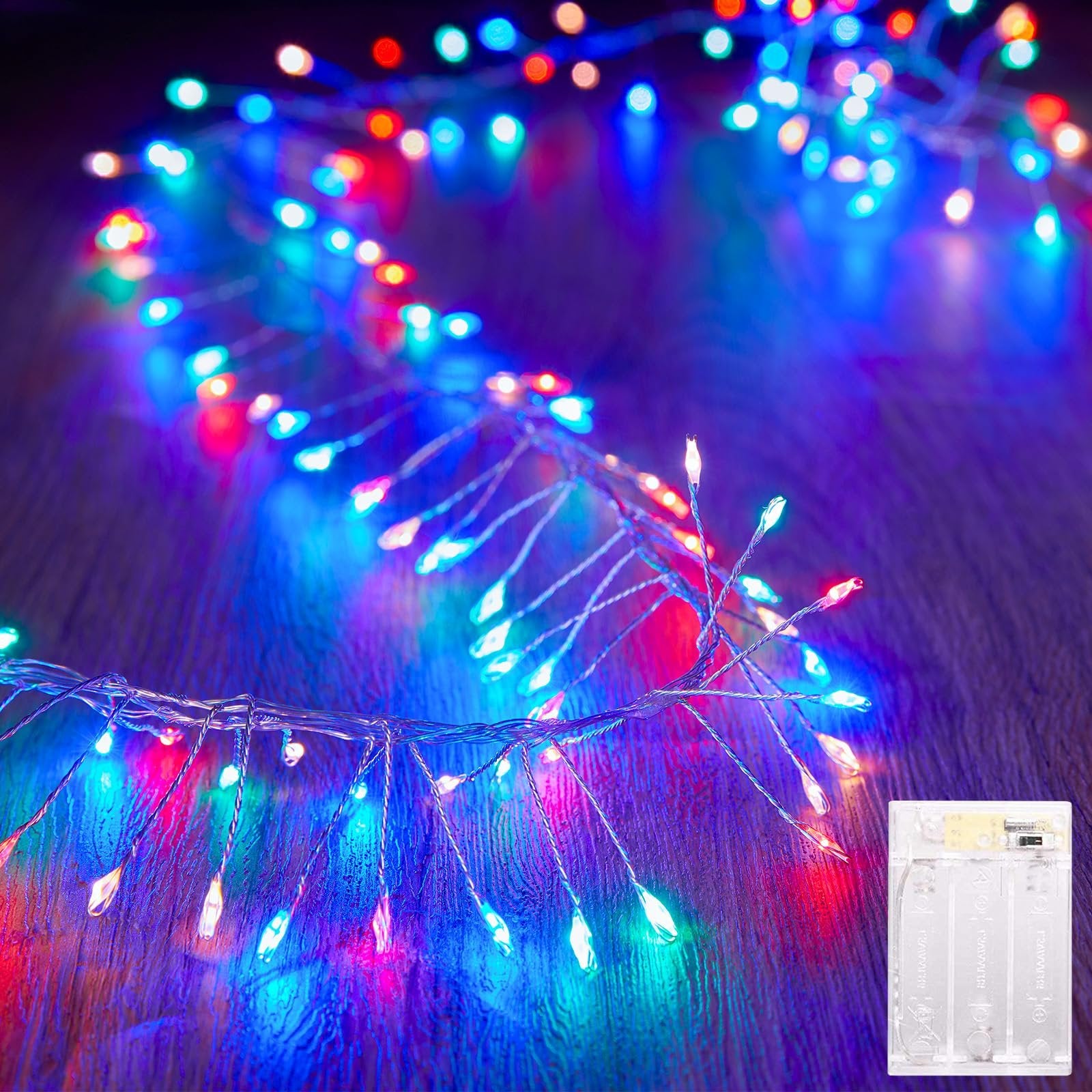 Multicolor firecracker string lights with silver wire and battery pack on a wooden surface
