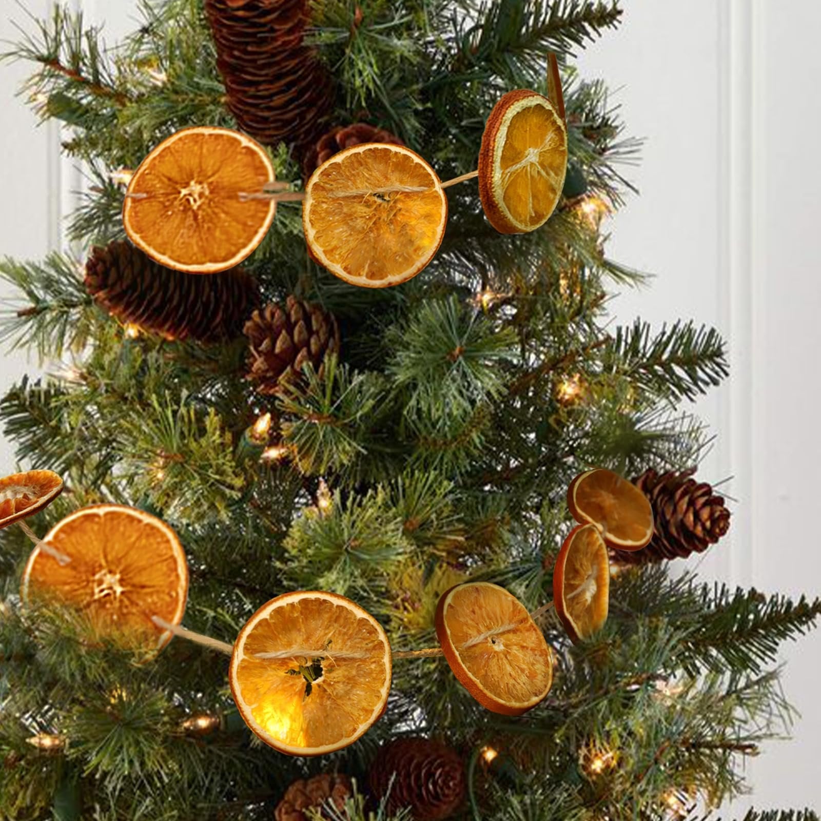 Dried orange slice garland with pine cones and lights on a Christmas tree