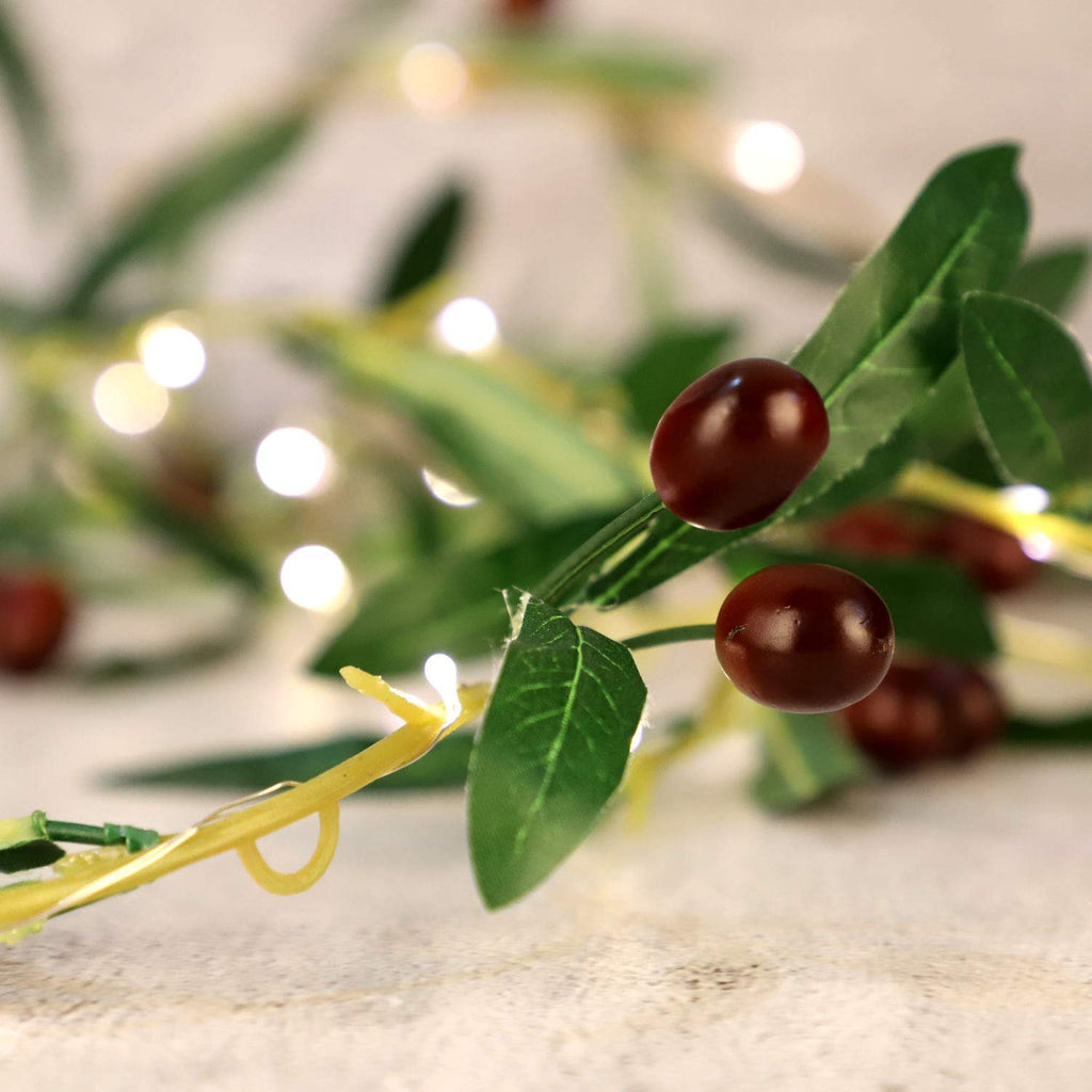 Close-up of an olive branch garland with warm white LED lights and faux olives.