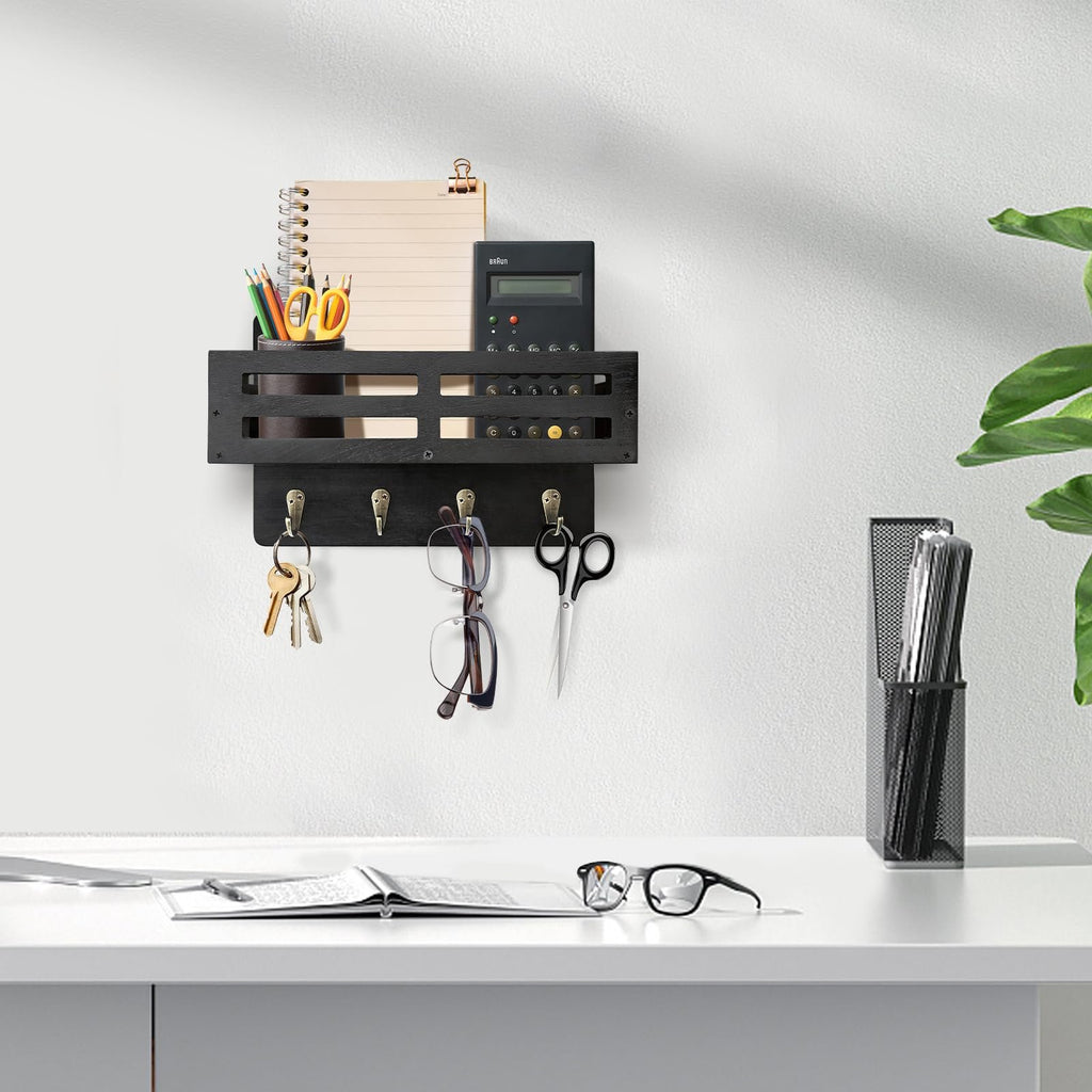 Black wooden key and mail holder wall mount with 4 hooks holding keys, glasses, and scissors. Organizer shelf above holds a notebook, pencils, and calculator.