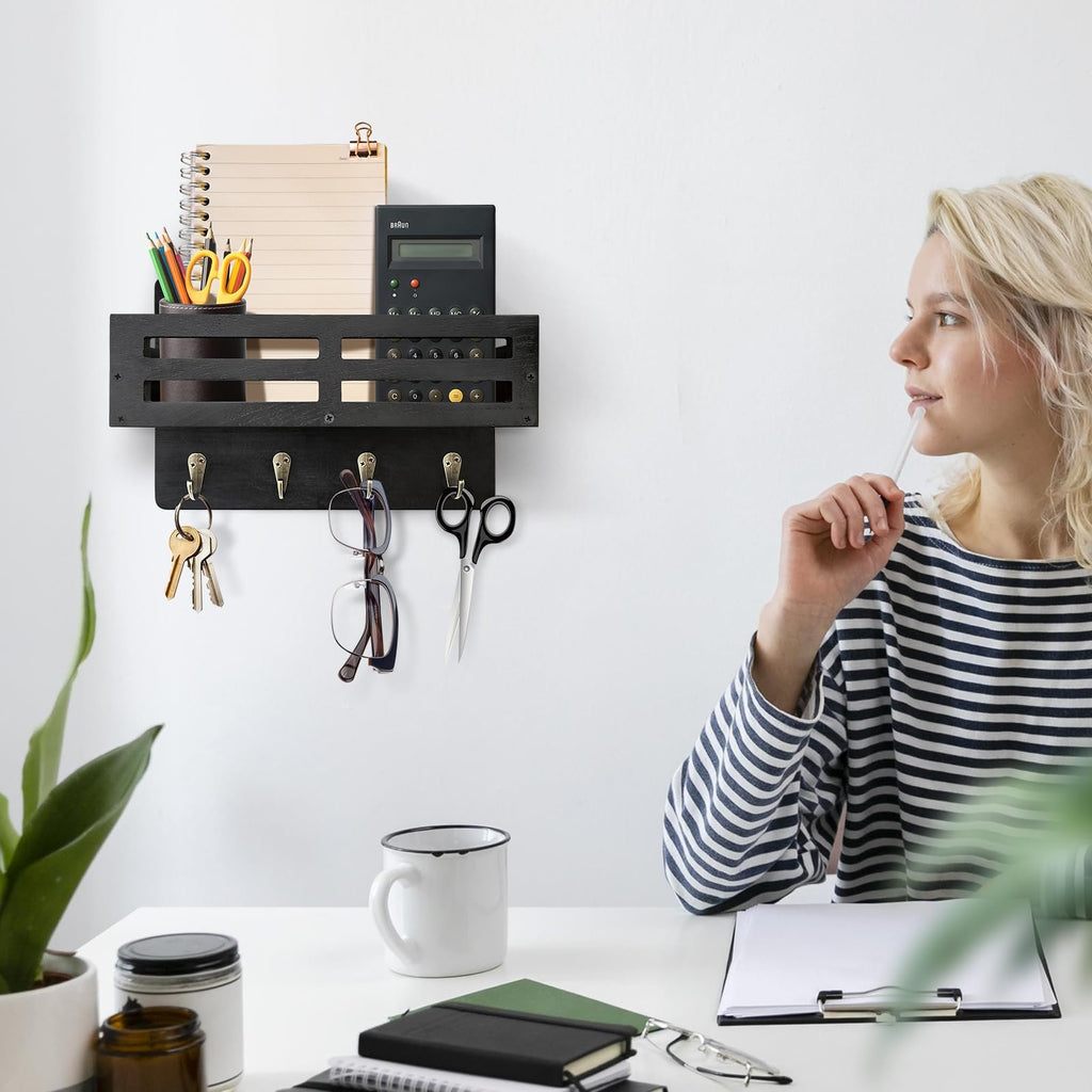 Black wooden key and mail holder with 4 hooks, organizer shelf, keys, glasses, and scissors hanging on a white wall.
