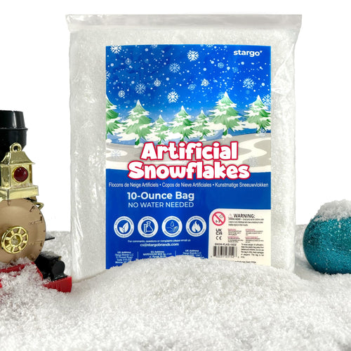 Bag of artificial snowflakes with a Christmas village scene on the packaging, surrounded by faux snow and a toy train.