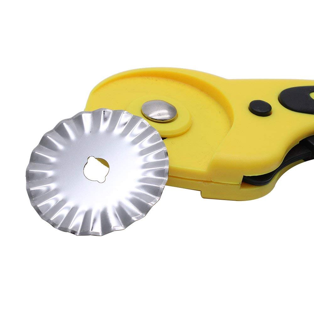 Close-up of a pinking rotary cutter blade and part of the yellow handle against a white background.