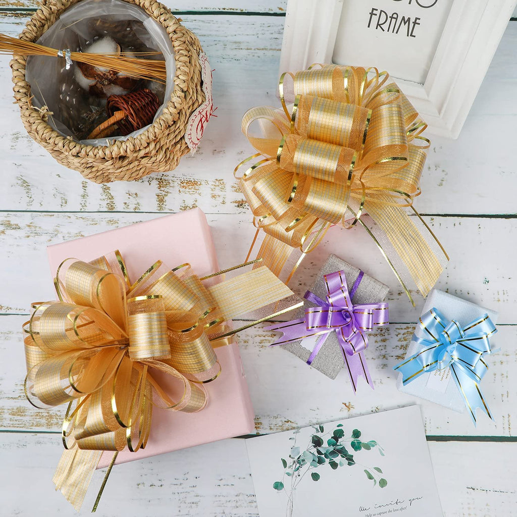 Gold pull bows on gift-wrapped boxes with a decorative basket and card on a wooden surface