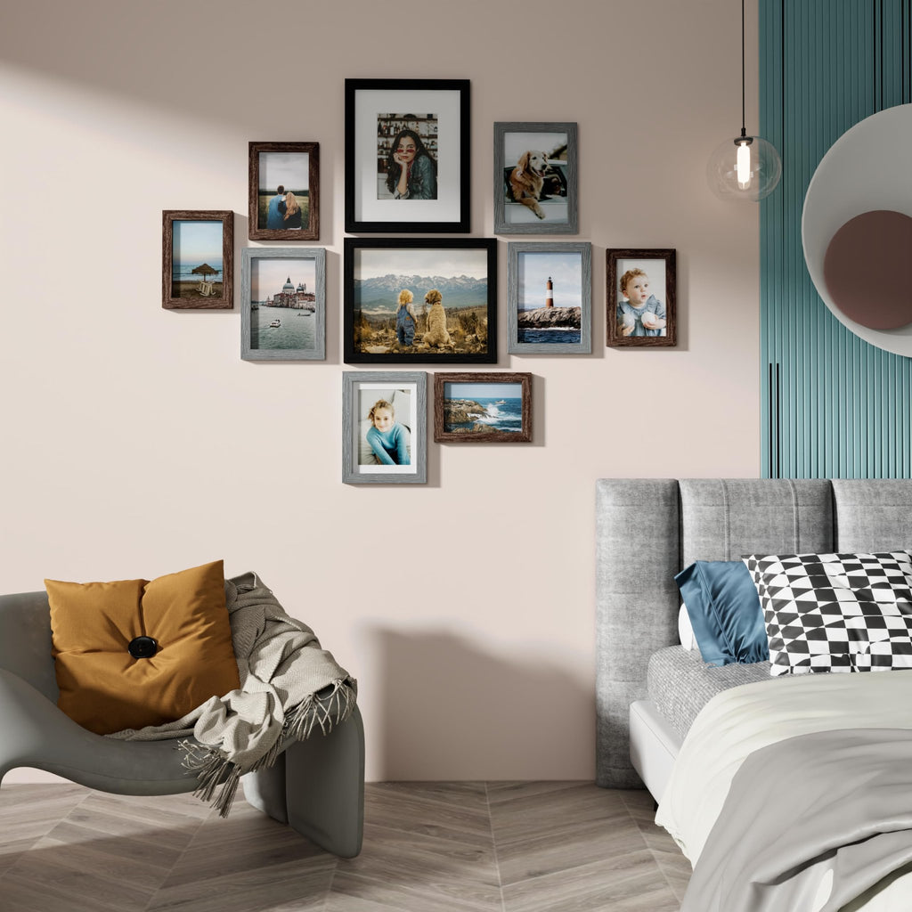 Gallery wall of ten picture frames arranged on a wall above a chair and bed. Frames display various photos.