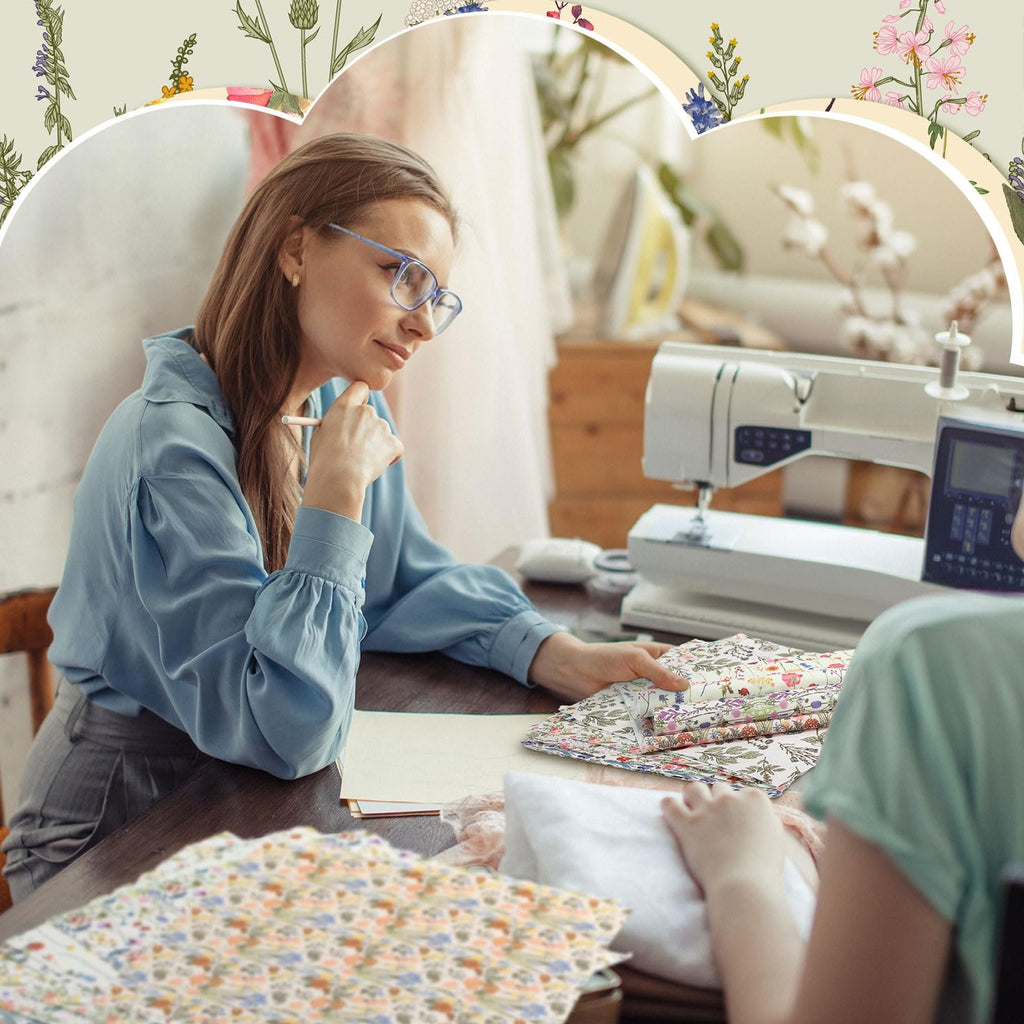 Woman with glasses looking at floral fabric bundles next to a sewing machine, with botanical illustrations framing the scene.