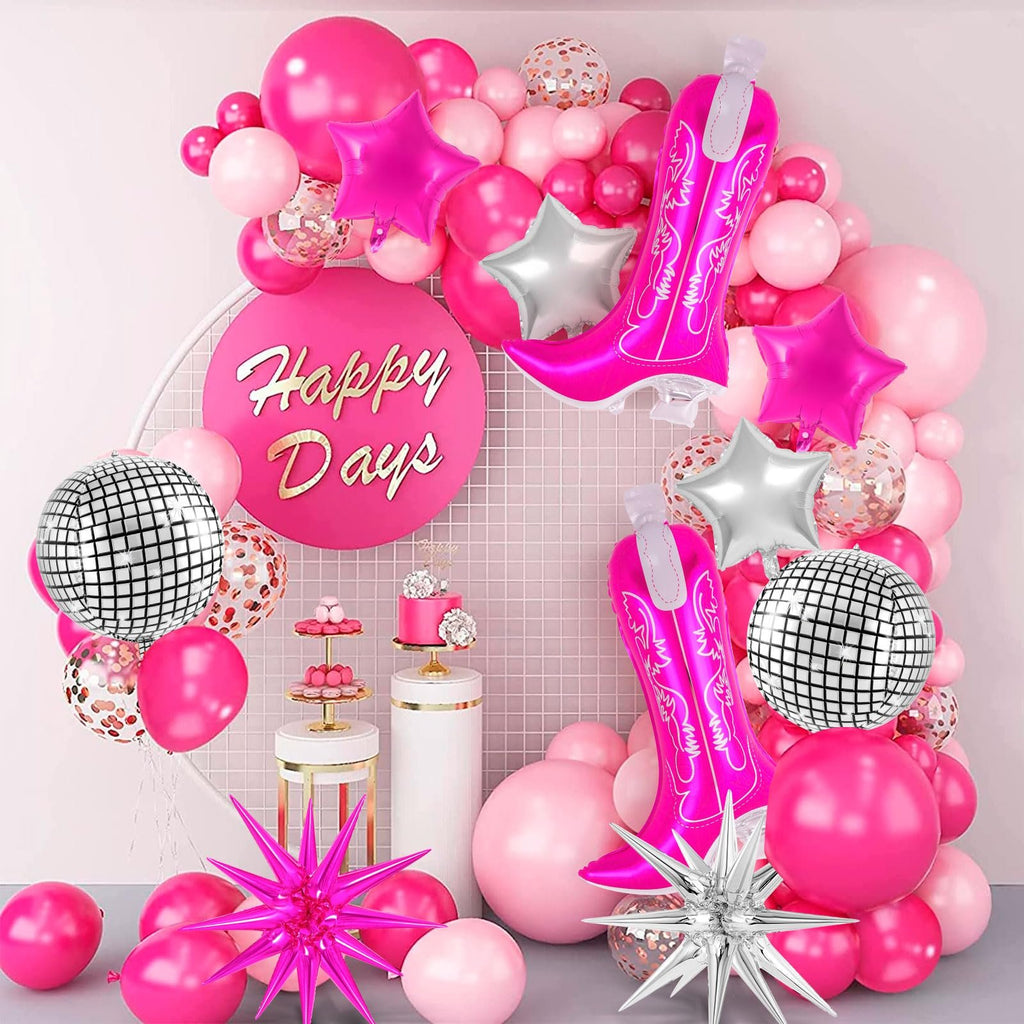 Pink cowgirl boot balloons and star balloons arranged in a party backdrop with disco balls and confetti balloons.