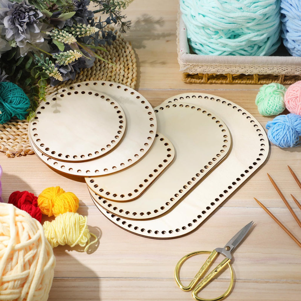 Assorted wooden basket bottoms for crochet, with yarn and knitting needles on a wooden surface.