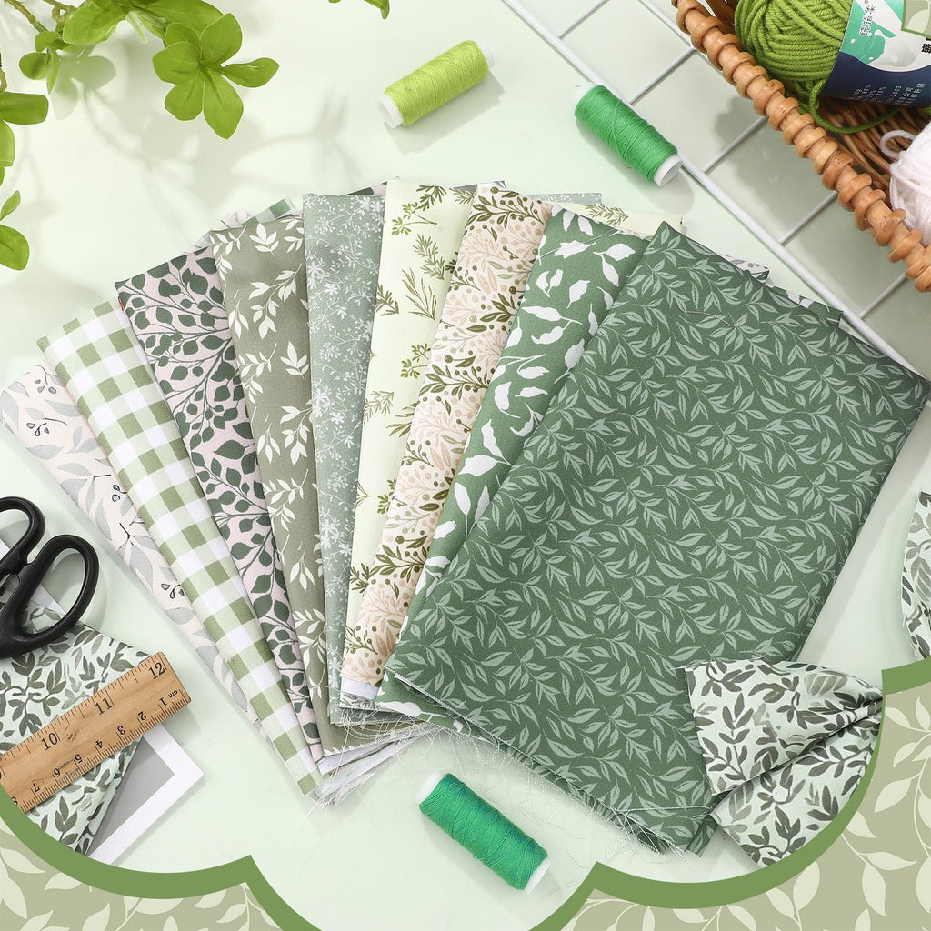 Sage green fat quarter fabric bundle with botanical leaf and plaid patterns, shown fanned out with scissors, ruler, and thread spools.