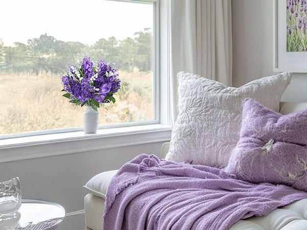 Artificial purple and white lilac and campanula bouquet in a white vase on a windowsill