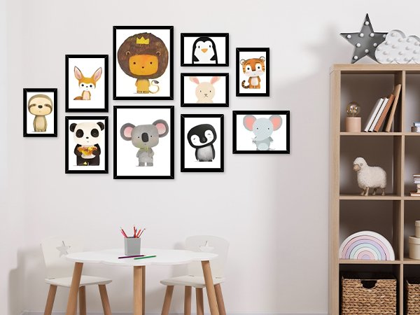 Collage of 10 framed animal prints displayed on a wall above a child's table and chairs.