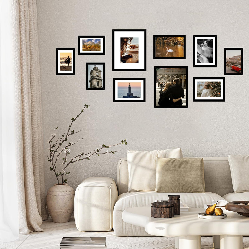 Collage of ten black picture frames displaying various scenic photos and portraits, arranged on a textured wall above a sofa.