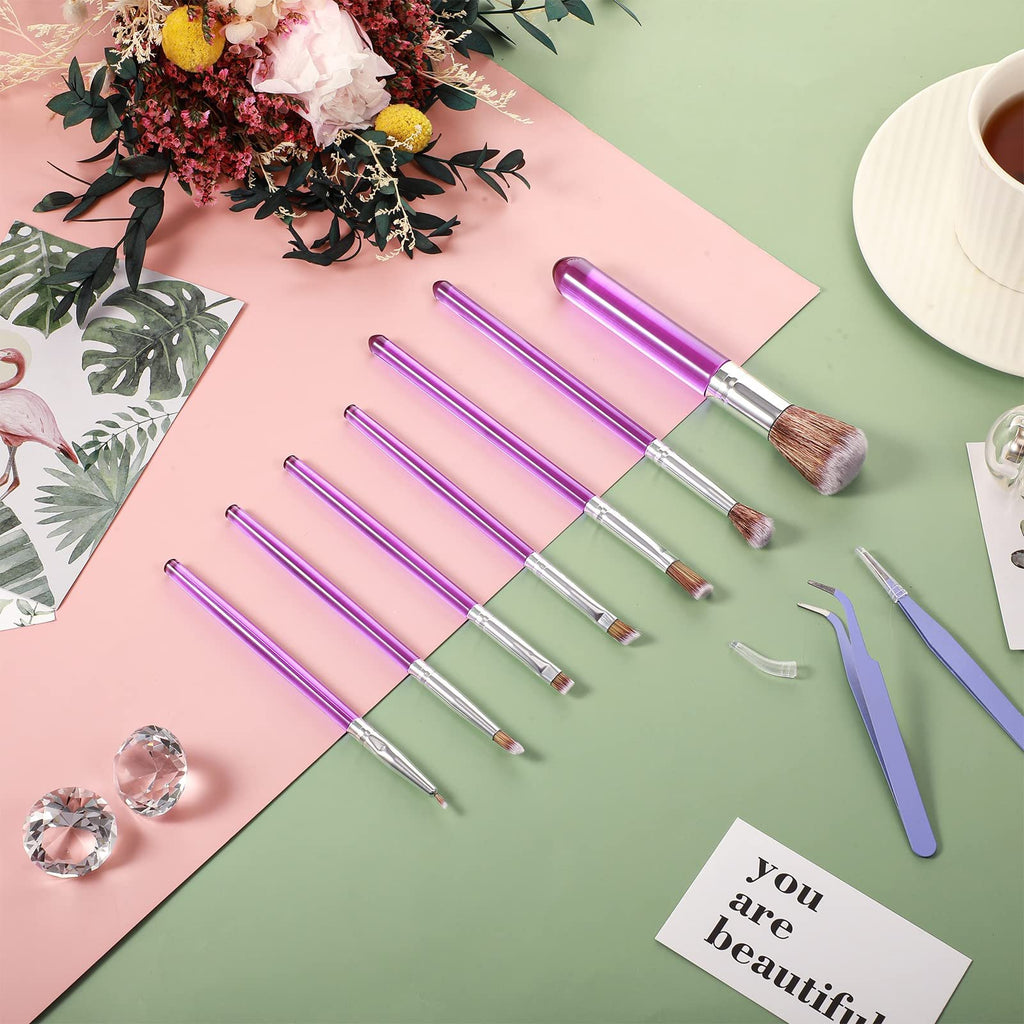 Purple cake decorating brushes and tweezers arranged on a pink and green surface with decorative elements.