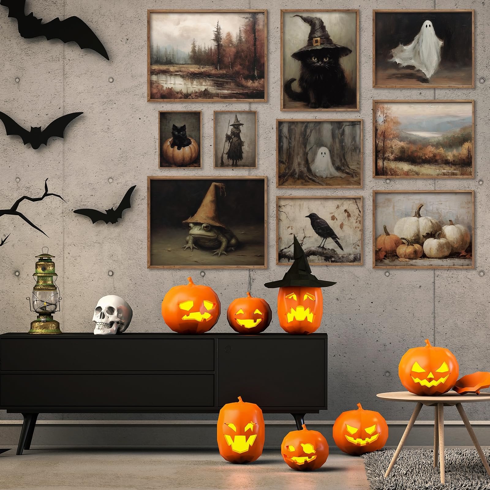 Halloween gothic wall art prints featuring black cats, witches, ghosts, and pumpkins displayed on a concrete wall above a black dresser with carved pumpkins.