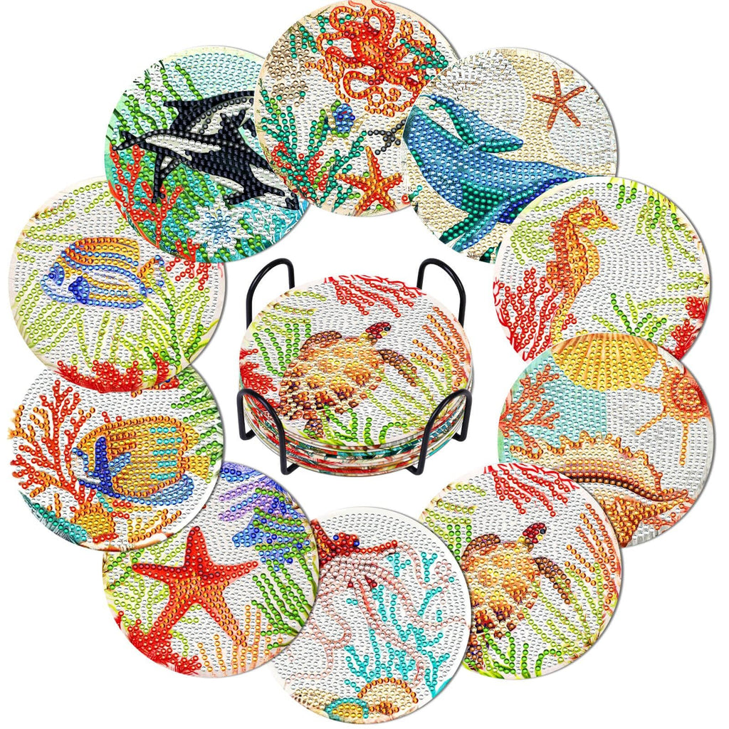Ten ocean-themed diamond painting coasters with various sea creatures and coral, displayed in a black metal holder.