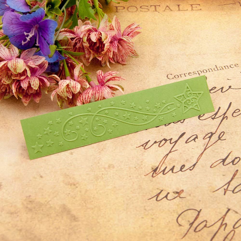 Green plastic embossing folder with star and swirl pattern, next to artificial flowers on textured paper.