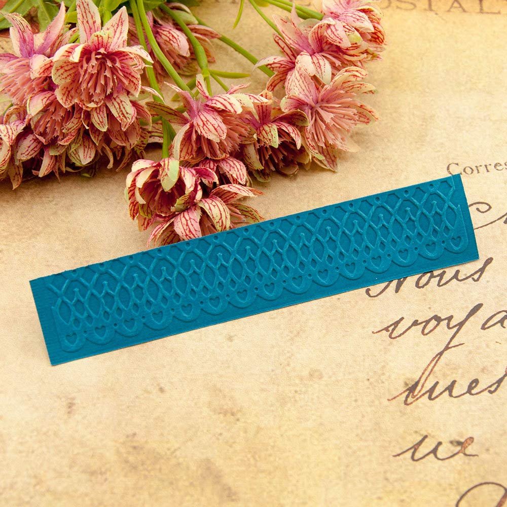 Teal plastic embossing folder with lace and heart pattern on vintage paper background with flowers