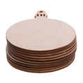 Stack of round unfinished wood Christmas ornaments with hanging loops on a white background.