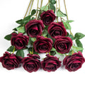Ten burgundy silk roses with green leaves arranged on a white background.