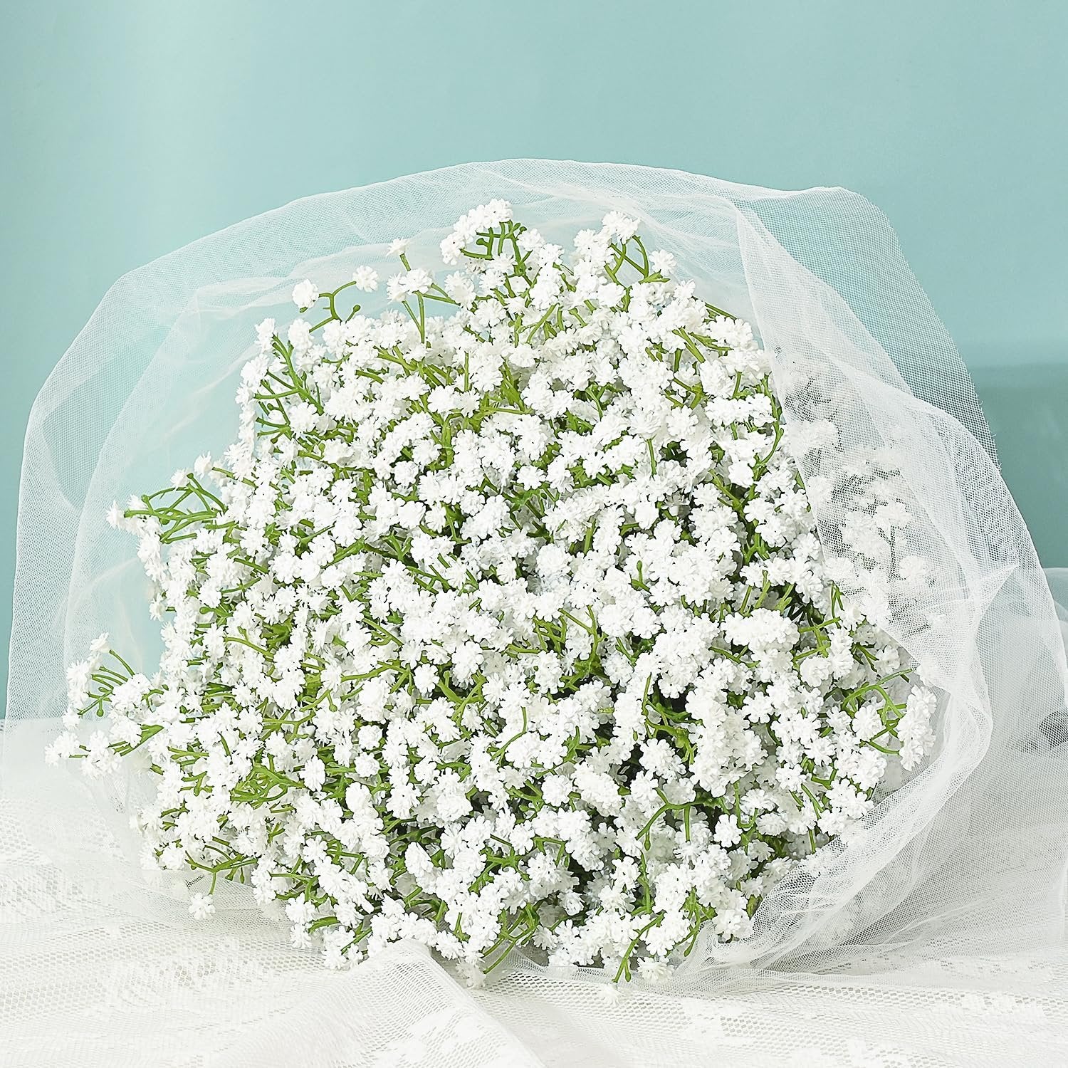 Bouquet of white artificial baby's breath flowers wrapped in white tulle and lace
