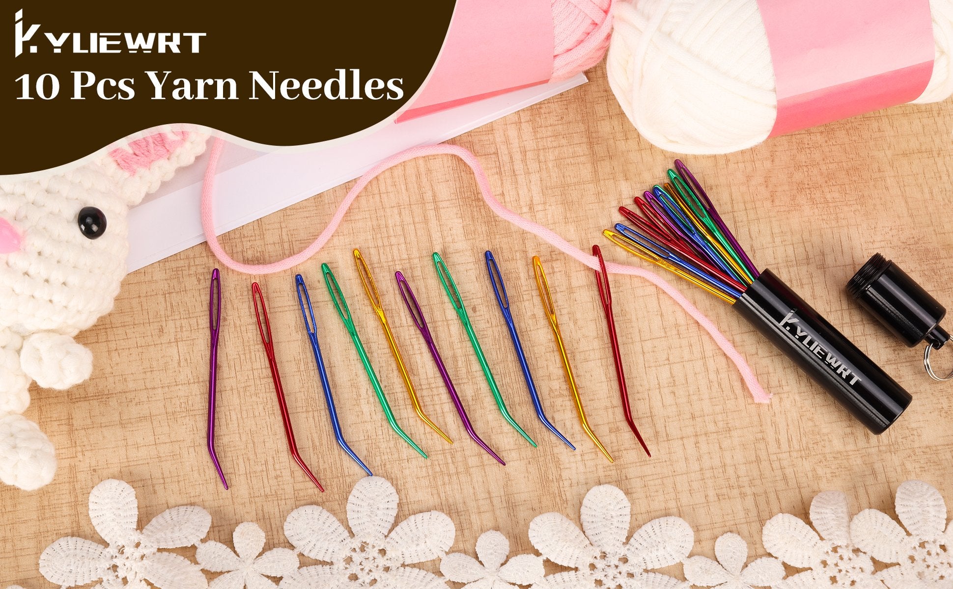 Set of 10 bent yarn darning needles with large eyes, stored in a black aluminum tube, with yarn and a crocheted bunny figure.