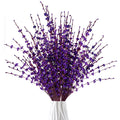 Bouquet of dark purple artificial jasmine flowers in a white vase, close-up view