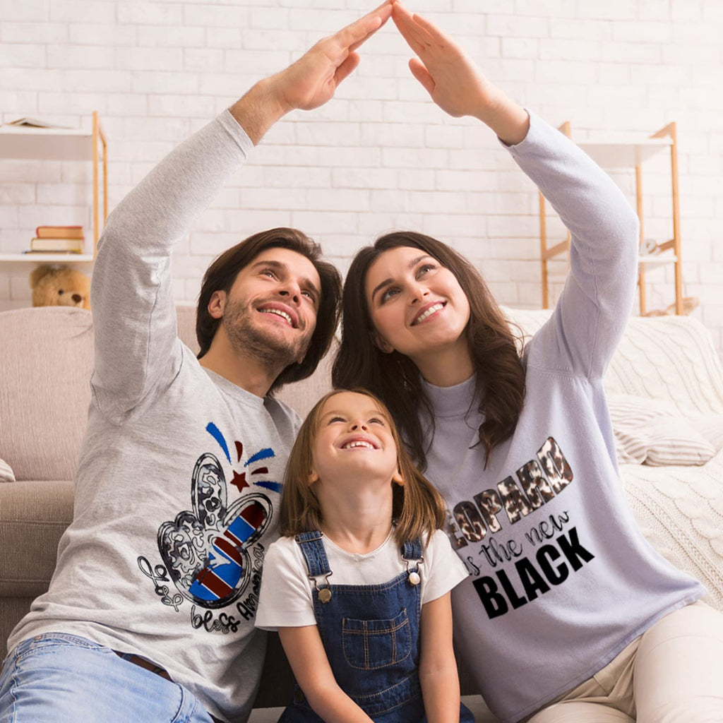 Family forming a house shape with their hands over their heads, looking up and smiling.