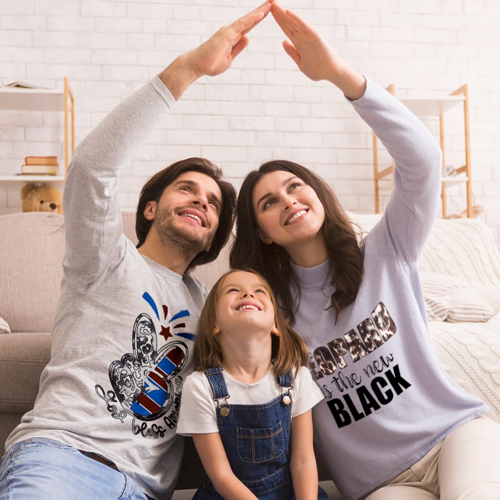 Family forming a house shape with their hands over their heads, looking up and smiling.