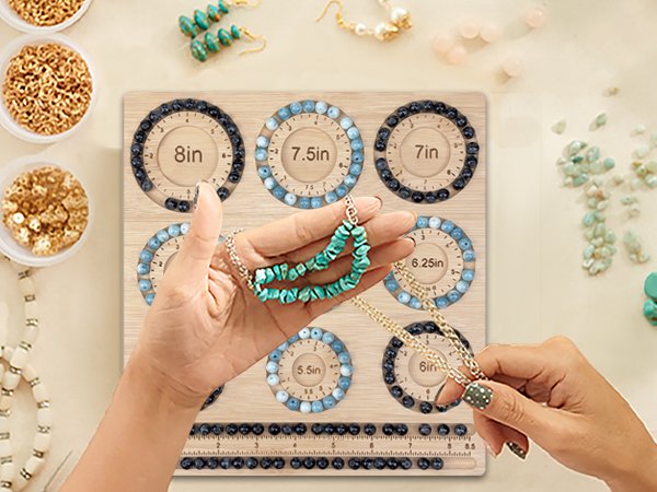 Hands holding turquoise beaded necklace over a wooden jewelry making board with size markings and bead storage slots.