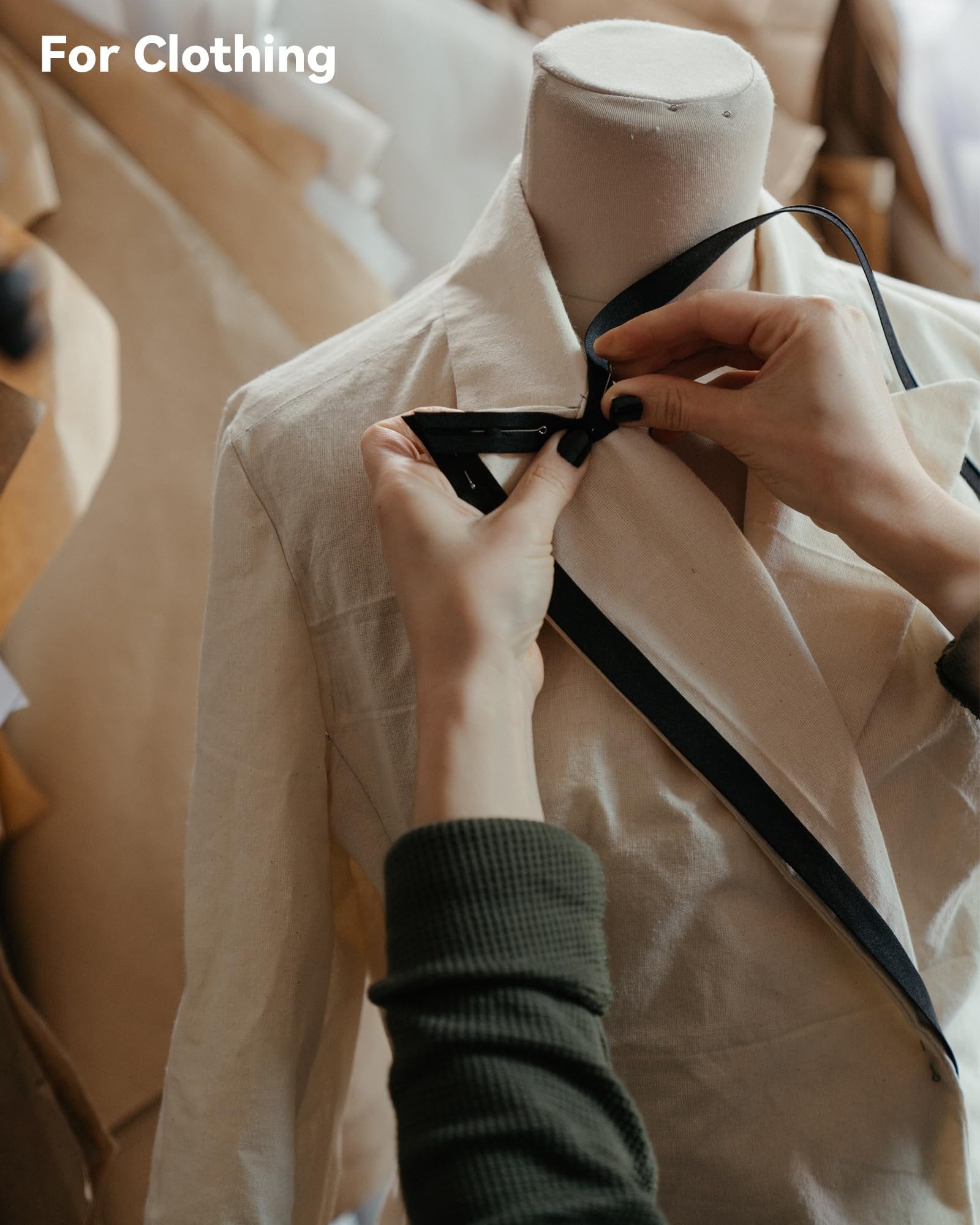 Hands pinning black ribbon to a cream-colored fabric draped over a mannequin, with 'For Clothing' overlay.