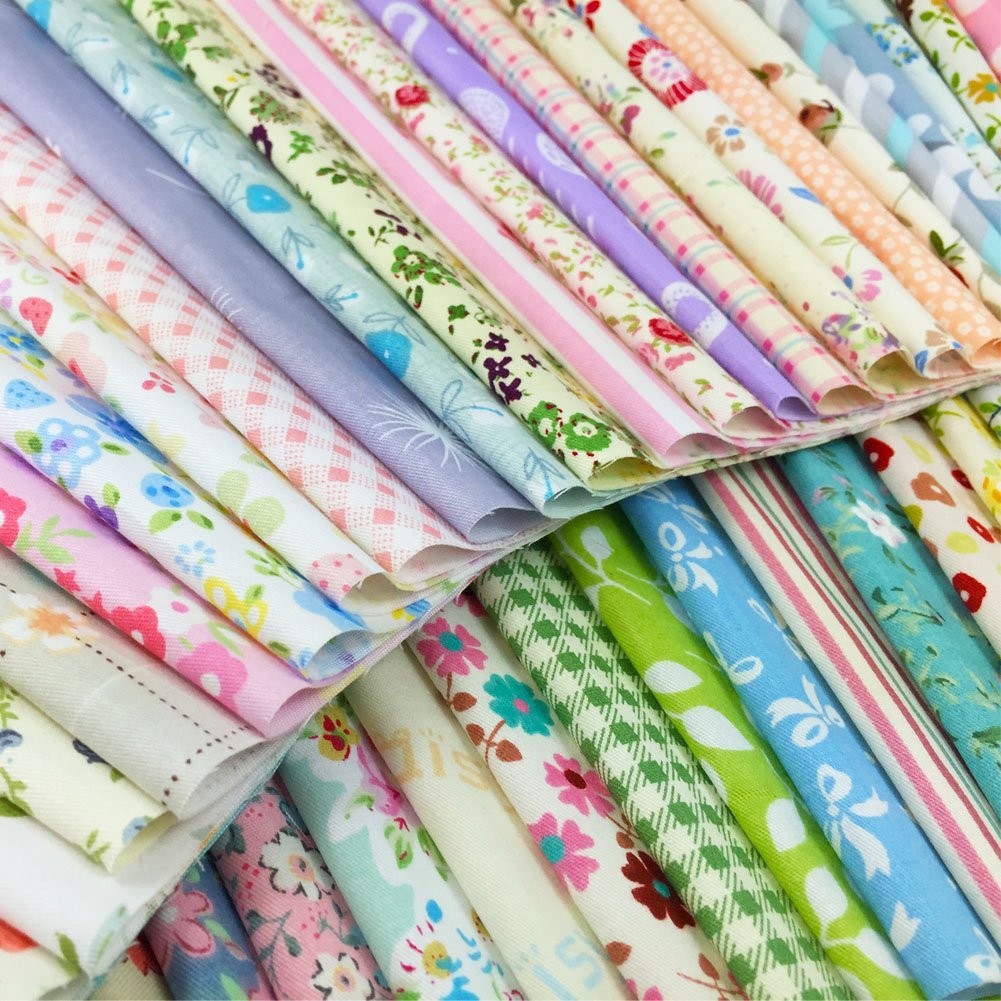 Close-up of a stack of assorted floral, polka dot, stripe, and gingham fabric squares in pastel colors.