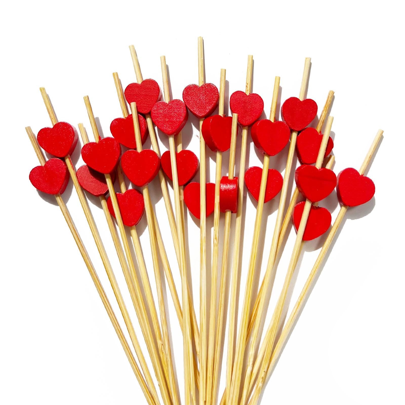 A fan of bamboo cocktail picks with red heart tops on a white background.