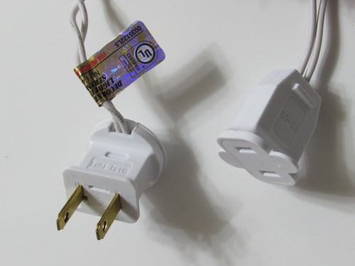 Close-up of two white electrical plugs for string lights, one labeled 'FUSE PLUG' and the other 'TS-55', with a UL certification tag.