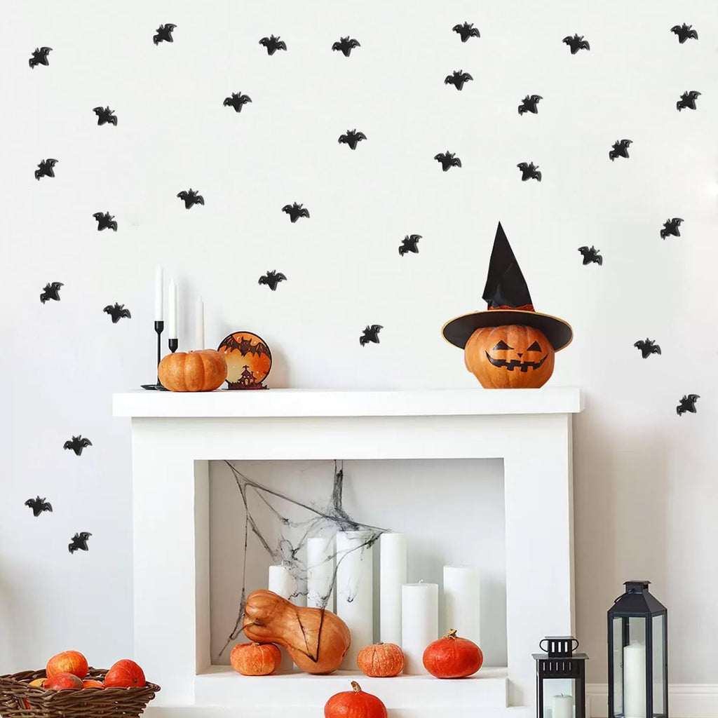 Halloween mantelpiece decorated with miniature bats, pumpkins, and candles